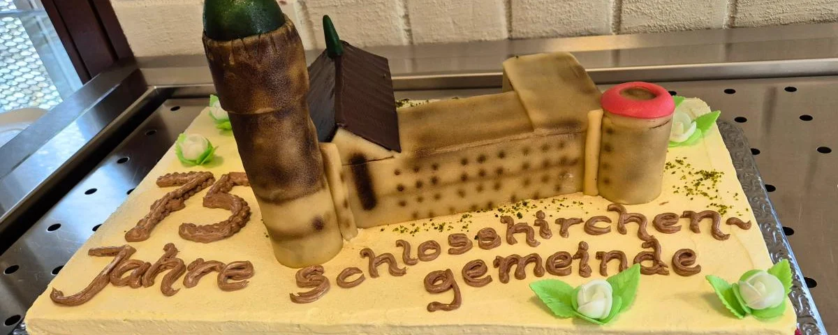 Ein Kuchen mit der Schlosskirche als Dekoration und dem Schriftzug "75 Jahre Schlosskirchengemeinde"