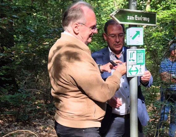 Ministerpräsident Reiner Haseloff und Dr. Ekkehard Steinhäuser von der Deutschen Lutherweg-Gesellschaft bringen ein Schild für die neue Lutherwegerweiterung an.