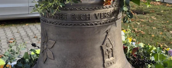 Die neue Bronzeglocke geschmückt mit Blumen.