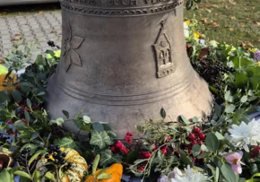 Die neue Bronzeglocke geschmückt mit Blumen.