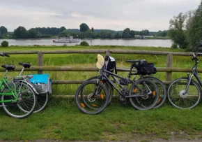 Fahrräder am Zaun, im Hintergrund ein Schiff auf einem Fluss | Foto: Birgit Arndt / fundus-medien.de